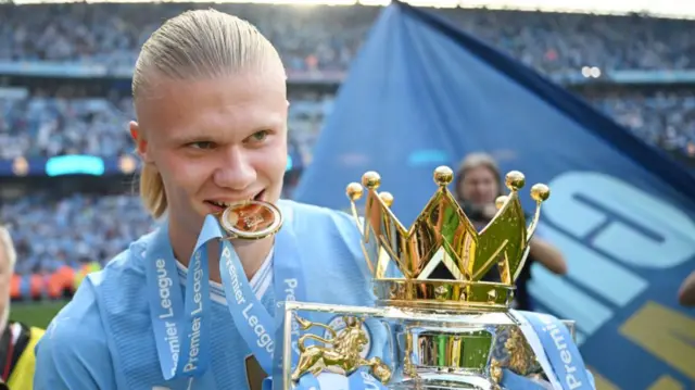 Erling Haaland biting a medal