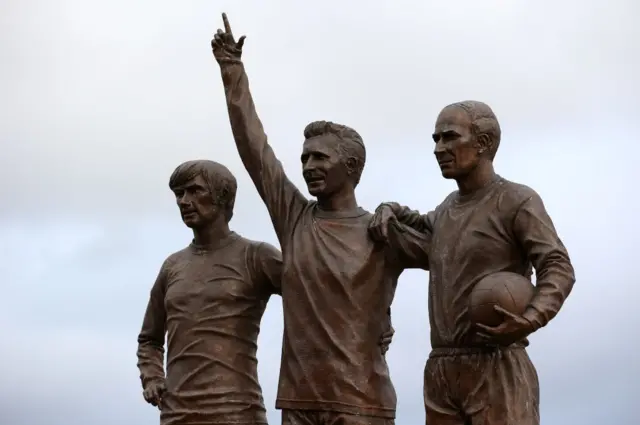 A statue of George Best, Denis Law and Sir Bobby Charlton outside Old Trafford