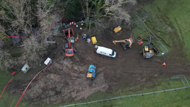 A drone shot of engineers working to fix the pipe