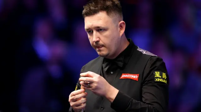 Kyren Wilson chalks his cue