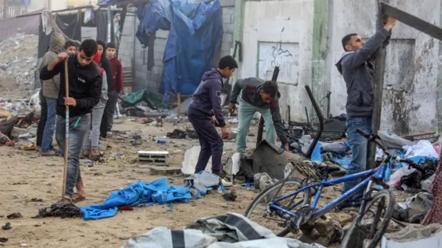 Palestinians inspect the destruction after an Israeli strike on tents in Khan Yunis, Gaza