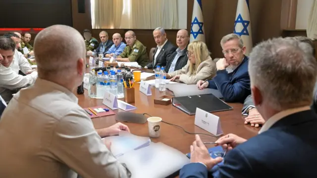 Lots of men, some in suits and some in army uniform, sitting round a table