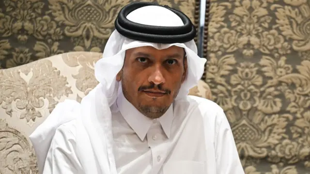 Mohammed bin Abdulrahman al Thani looks directly at the camera. He is wearing all white and has brown eyes.