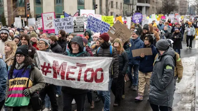 Crowds protesting and holding signs, including one which reads '#MeToo'