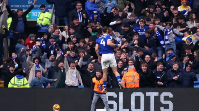 Dimitrios Goutas leaps in celebration in front of the Cardiff fans