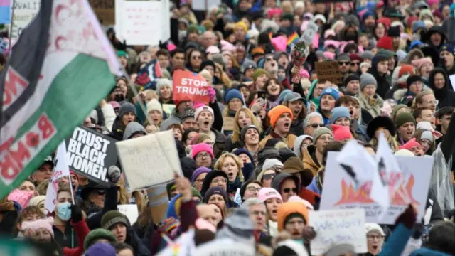 A crowd of protestors holding placards