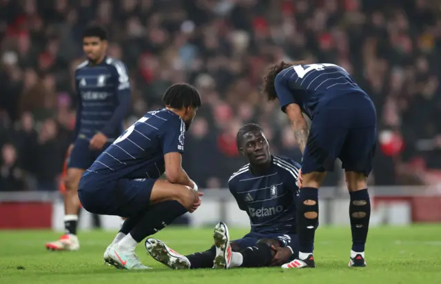 Amadou Onana of Aston Villa is checked on by teammates.