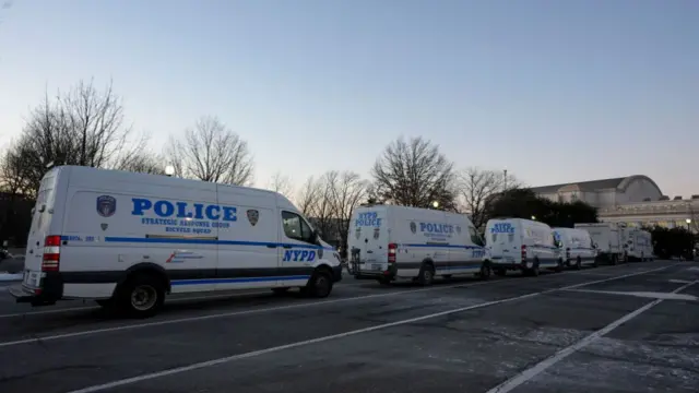 White police vans line a road in DC