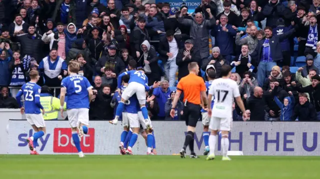 Cardiff players and fans celebrate their first goal against Swansea