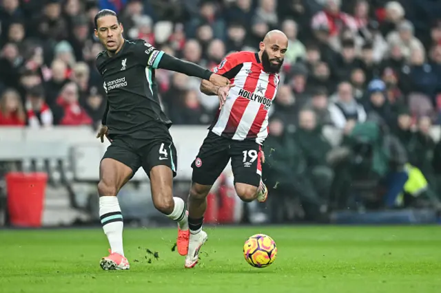 Virgil van Dijk fights for the ball with Bryan Mbeumo