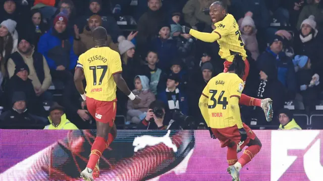 Edo Kayembe leaps into the air after scoring for Watford at Derby