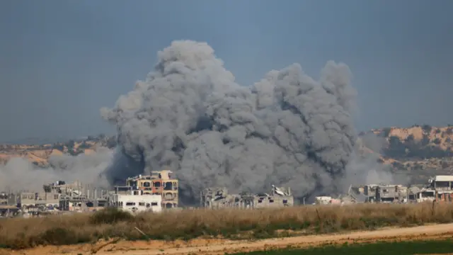 A huge cloud of smoke rises about burnt out houses in northern Gaza