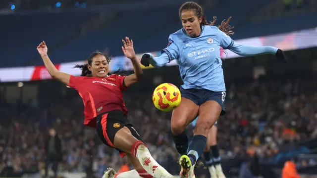 Mary Fowler of Manchester City (R) is tackled by Jayde Riviere of Manchester United during the Barclays Women's Super League match between Manchester City and Manchester United at Etihad Stadium