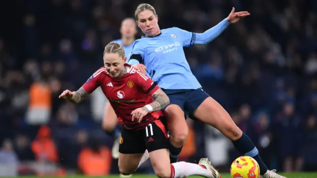 Leah Galton of Manchester United (L) is challenged by Rebecca Knaak of Manchester City during the Barclays Women's Super League match between Manchester City and Manchester United