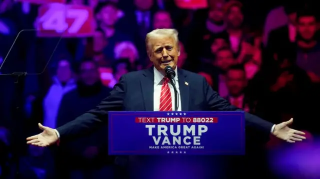 Trump holds his hand out as he addresses the crowd at his rally in DC