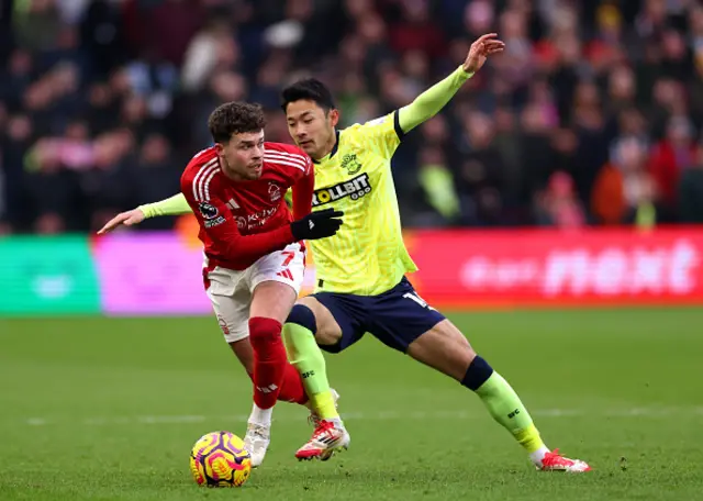 Neco Williams of Nottingham Forest is challenged by Yukinari Sugawara