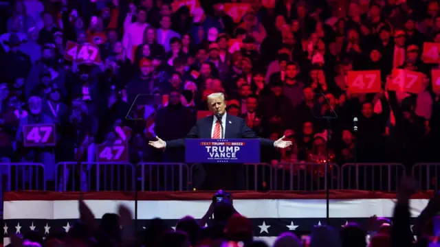 Trump holds his hands out as he addresses the crowd from the lectern