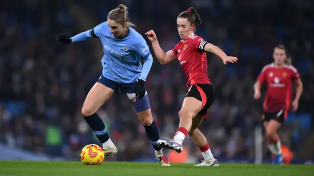 Vivianne Miedema of Manchester City runs with the ball whilst under pressure from Maya Le Tissier of Manchester United during the Barclays Women's Super League match between Manchester City and Manchester United