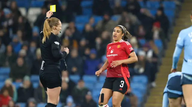 Manchester United's Gabrielle George is shown a yellow card by referee Lisa Benn during the Barclays Women's Super League match at Etihad Stadium,