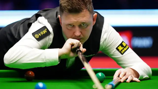 Kyren Wilson plays a shot with the rest