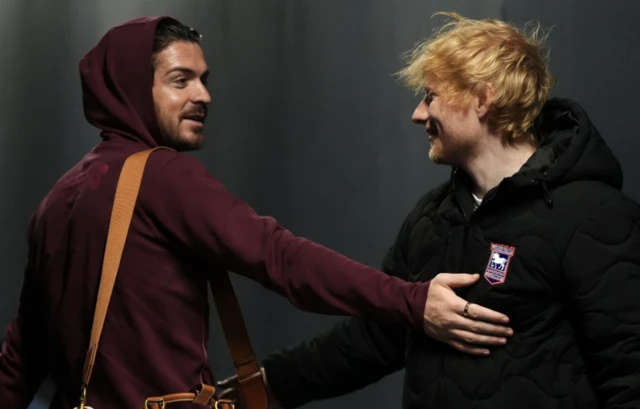 Manchester City's Jack Grealish greets Ipswich Town stakeholder Ed Sheeran