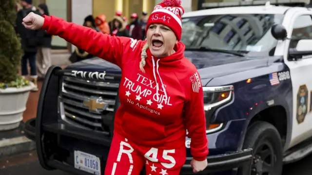 A woman wearing an all red outfit which reads "Texas Trump girl: no apologies"