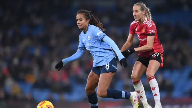 Mary Fowler of Manchester City (L) gets away from Millie Turner of Manchester United during the Barclays Women's Super League match between Manchester City and Manchester United at Etihad Stadium