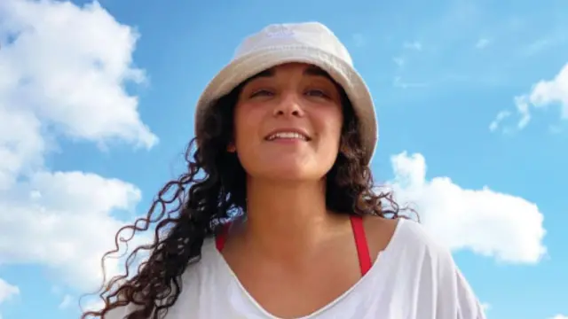 A photo of Emily Damari, given to the media by her family, shows her wearing a hat and white T-shirt in front of a blue sky