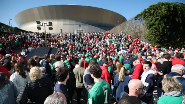 Hundreds of fans dressed in green and red surround the Superdome