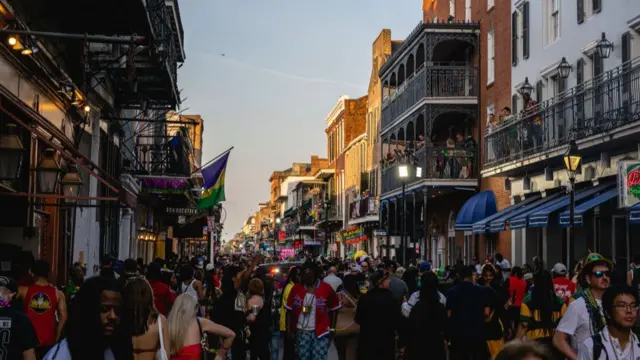 Party-goers walk down a crowded Bourbon Street in New Orleans during Mardi Gras celebrations