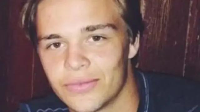 Martin "Tiger" Bech, a young man in a blue shirt, looks up at a camera and smiles