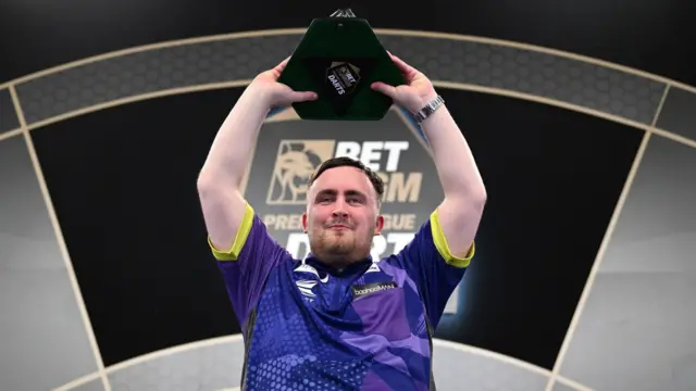 Luke Littler holds the Premier League trophy