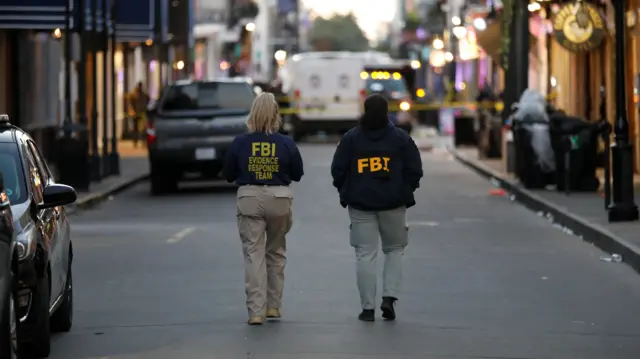 FBI agents walk near the site where people were killed by a man driving a truck in an attack during New Year's celebrations, in New Orleans, Louisiana