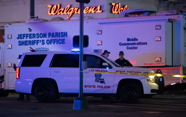 A Louisiana State Police car is parked outside a Mobile Communications Center