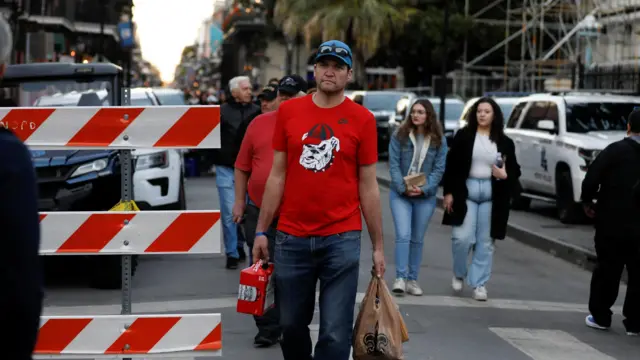 A University of Georgia fan walks near the site where people were killed by a man driving a truck in an attack during New Year's celebrations, in New Orleans, Louisiana