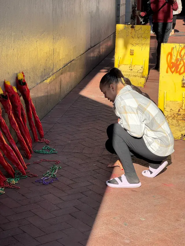 Woman kneels at New Orleans memorial display