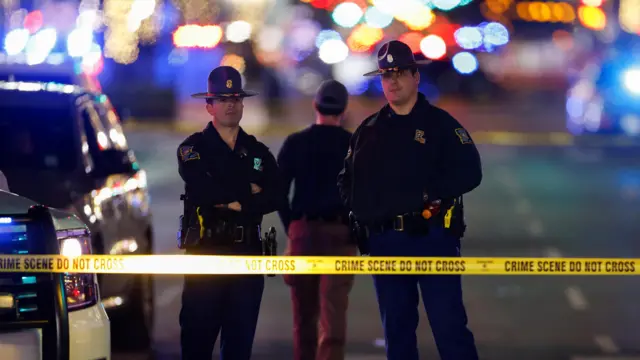 Louisiana state police personnel stand near the site where people were killed by a man driving a truck in an attack during New Year's celebrations, in New Orleans, Louisiana