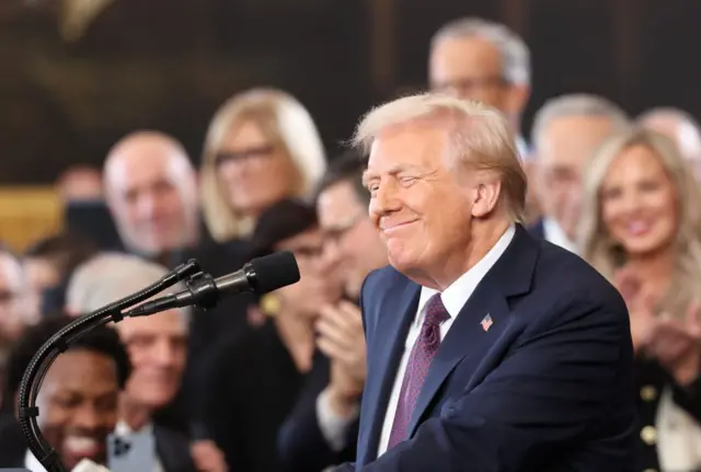 Trump smiling in front of a microphone