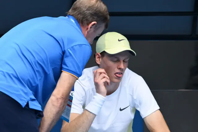 Jannik Sinner of Italy receives medical treatment in the Men's Singles Fourth Round match