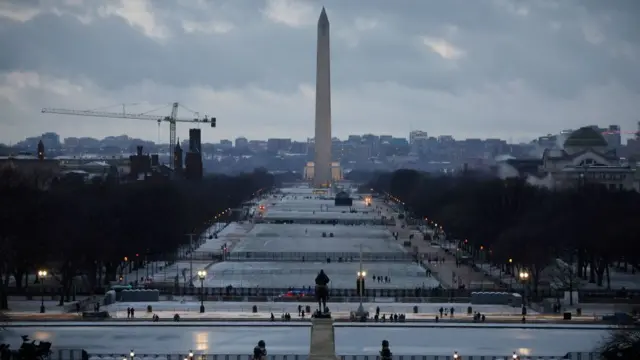 The washington monument and reflecting pool can be seen in the distance. In the foreground, gates have been established for inauguration attendees to congregate.