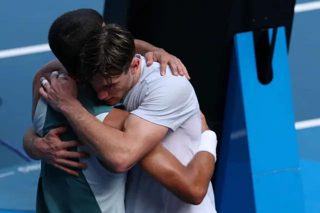 Jack Draper (R) of Great Britain is consoled by Carlos Alcaraz (L) of Spain