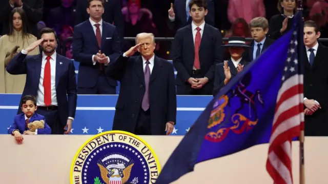 Trump and Vance salute as the parade goes past