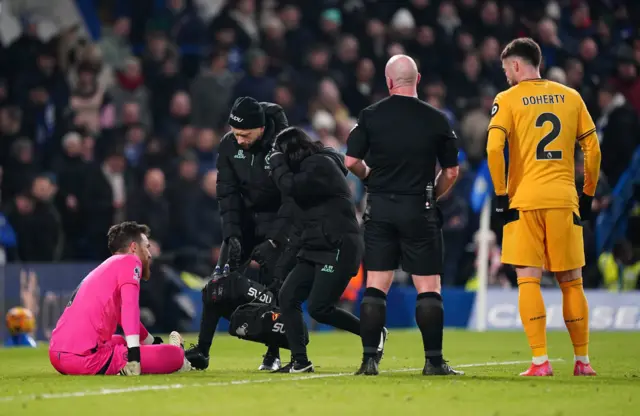 Sa sits on the floor as physios make their way to him