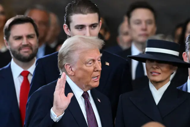 Trump holding up hand as he speaks