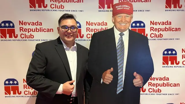 Schayden Gorai stands next to a cardboard cutout of the president.