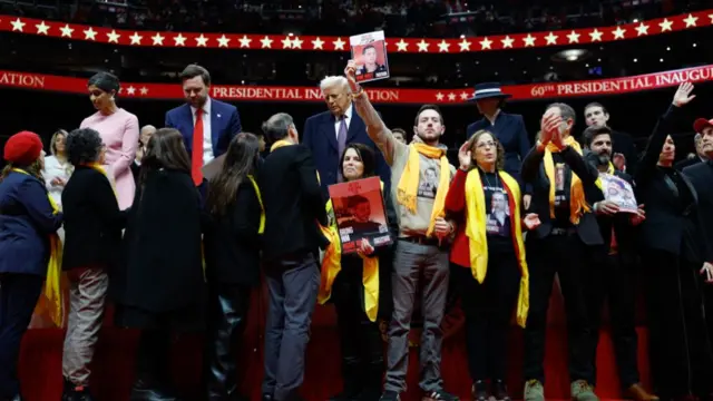 Hostages and their families stand on stage with President Donald Trump