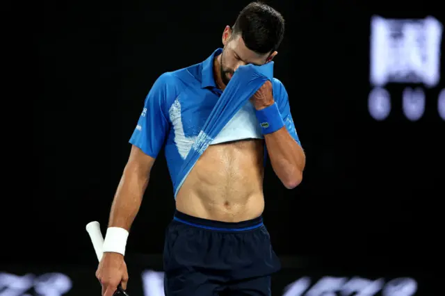 Novak Djokovic wipes his head with his shirt