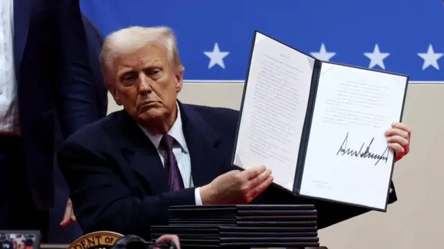 U.S. President Donald Trump shows his signature on an executive order that he signed in front of supporters inside the Capital One Arena during ceremonies on the inauguration day of his second presidential term, in Washington.