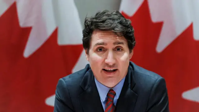 Canadian Prime Minister Justin Trudeau pictured in front of Canadian flags