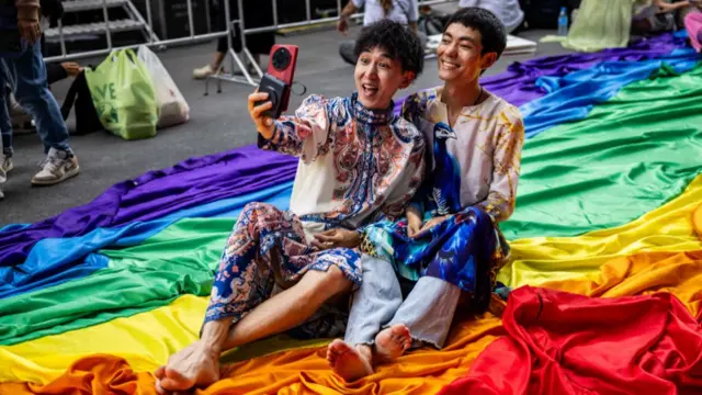 A couple poses for a photo at Central World Mall during the Bangkok Pride Parade on 1 June, 2024